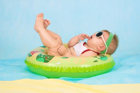 A baby in sunglasses on a pool float
